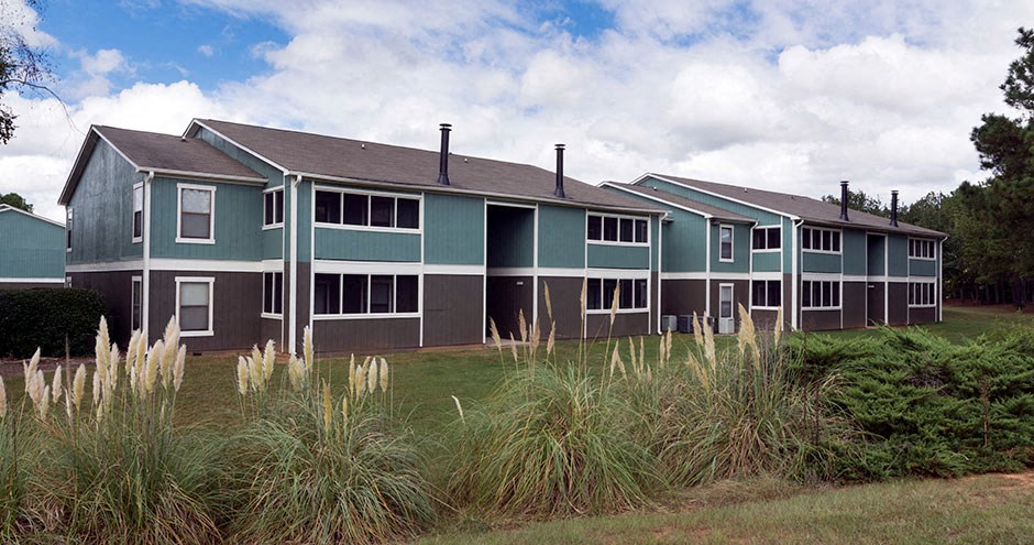 A row of houses with green roofs and white windows at Southland Station Apartments, Warner Robins, GA, 31088