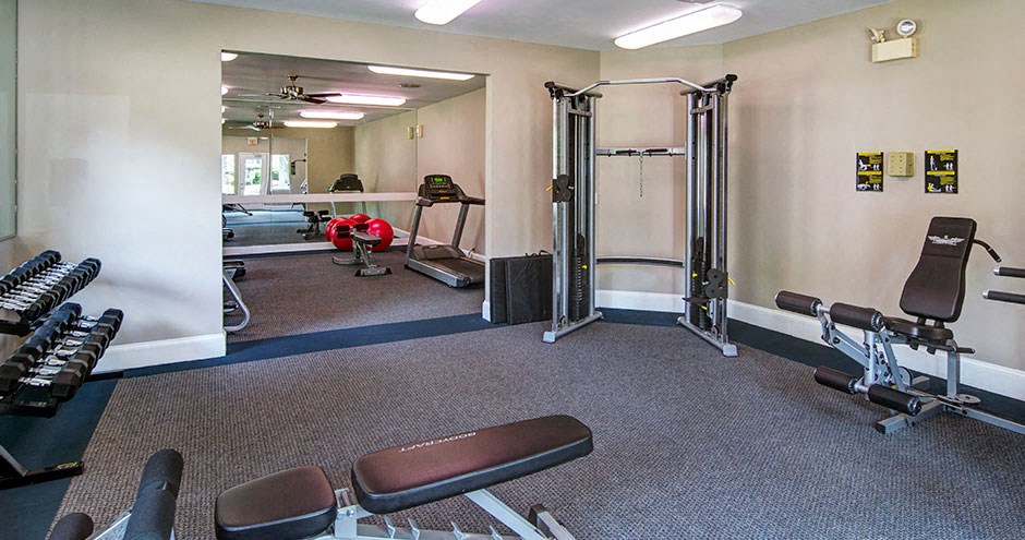 A gym with a variety of equipment including a treadmill, weights, and a bench press at Southland Station Apartments, Warner Robins, 31088