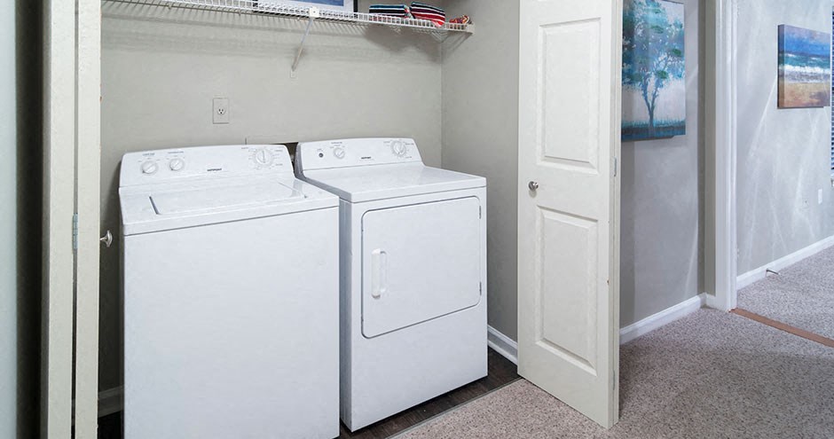 Two white washing machines in a small laundry room at Southland Station Apartments, Warner Robins, GA