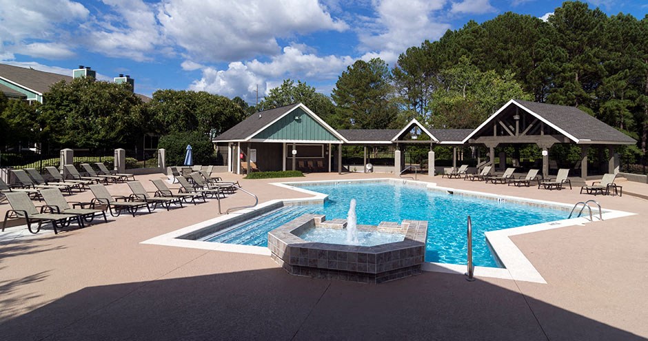 A pool with a fountain in the middle of it at Southland Station Apartments, Warner Robins, 31088