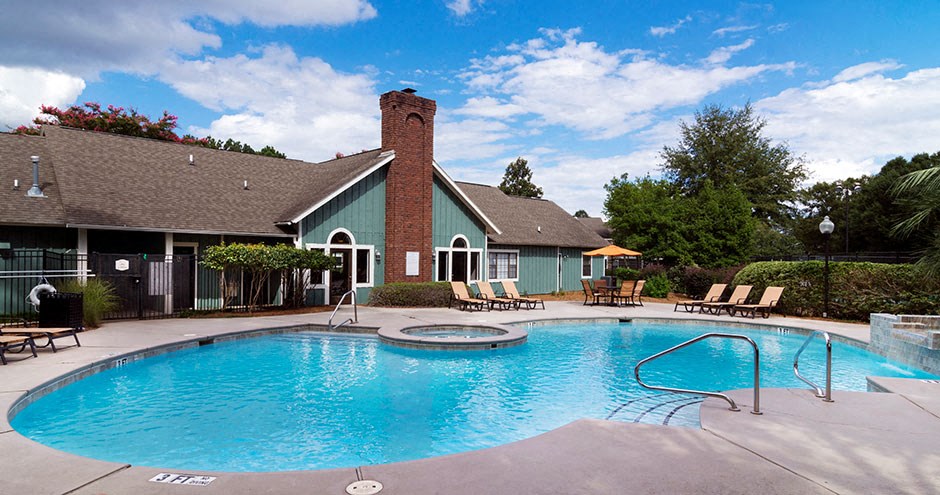 A pool with a blue water and a building beside it.