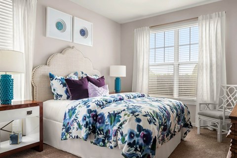Bedroom with floral bedding and upholstered headboard at Colony at Centerpointe Apartments, Midlothian, VA 23114