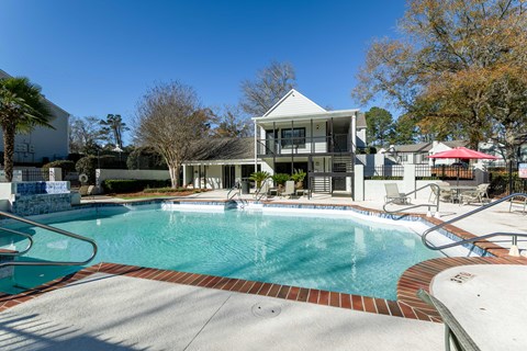 A swimming pool in front of a house.