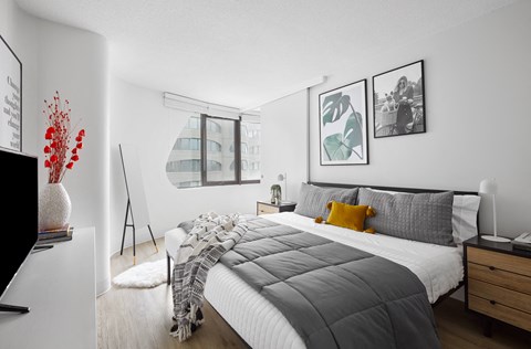 A bedroom with a large bed and a window overlooking a building.