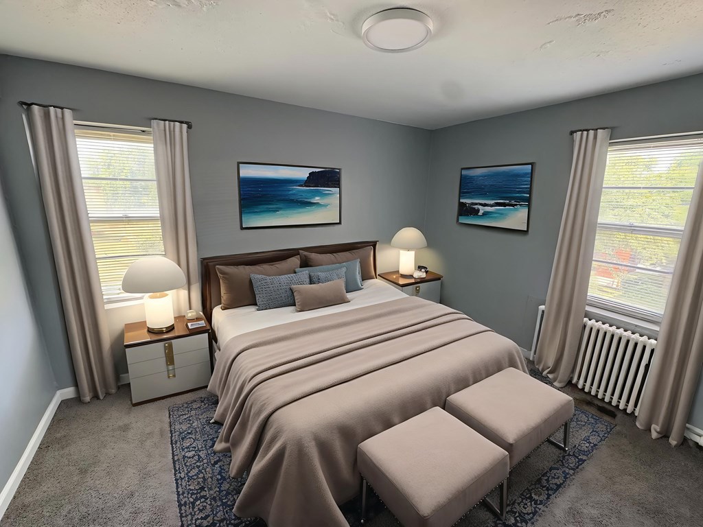 A bedroom with a large bed and two lamps.