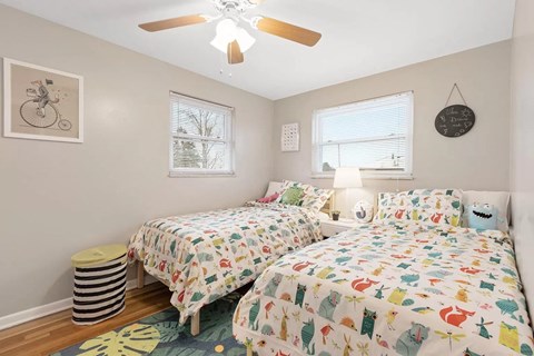 a bedroom with two beds and a ceiling fan