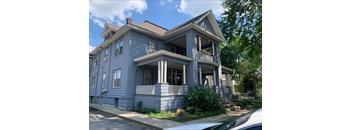 A two-story house with a balcony on the second floor.