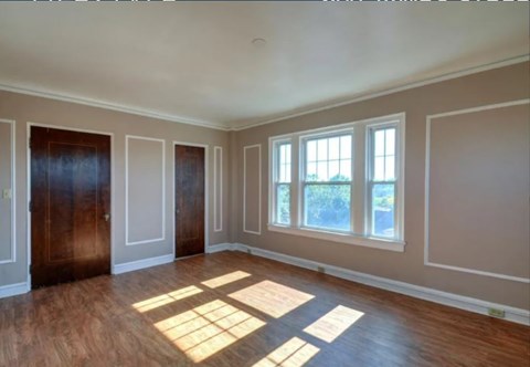 A room with wooden floors and a large window.