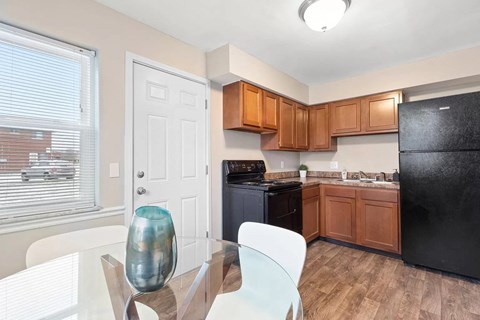 a kitchen with a glass table and a black refrigerator