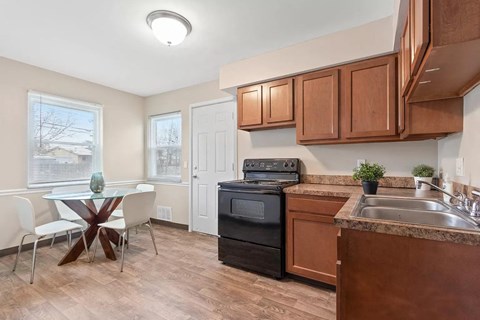 A kitchen with brown cabinets and a black oven.