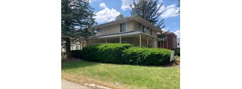 A house with a well-maintained green lawn in front.