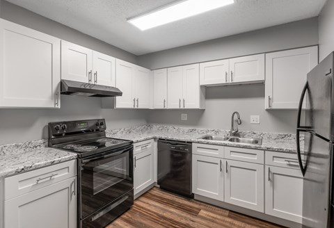 A kitchen with white cabinets and a black stove top oven.