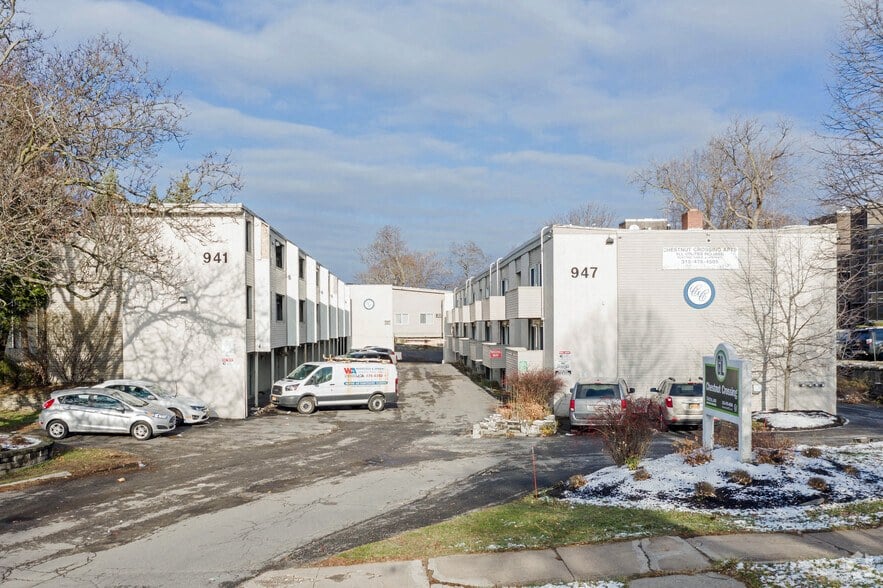 a group of white buildings with cars parked in front of them