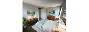 A bedroom with a bed, nightstands, and a painting on the wall.at The Summit, Syracuse, 13210