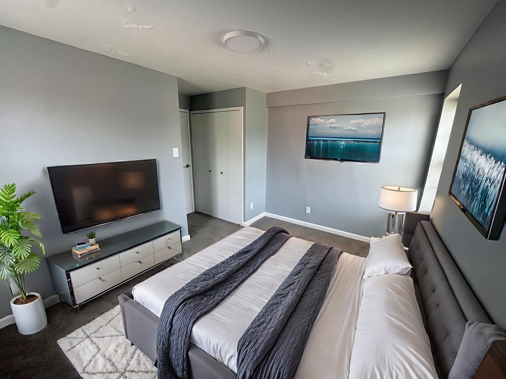 A bedroom with a large bed and a television.