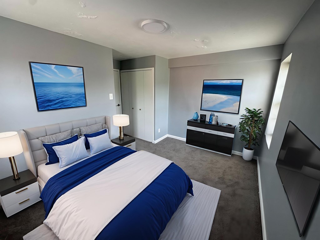 A bedroom with a large bed and a painting of a beach on the wall.