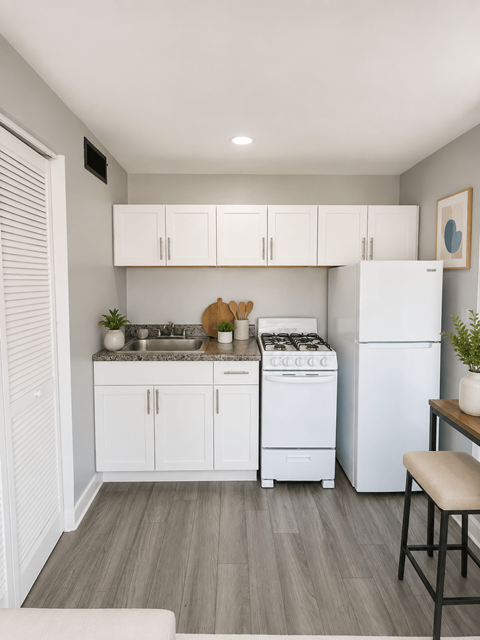 A kitchen with white cabinets and a white refrigerator.