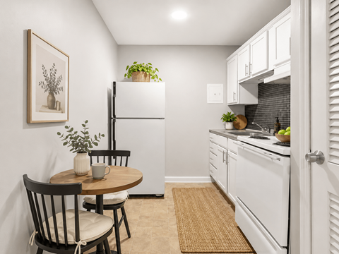 A kitchen with a table and chairs and a fridge.
