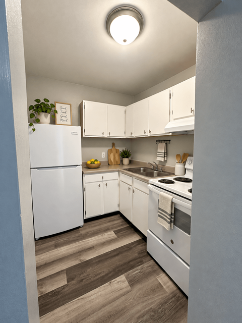 A kitchen with white appliances and cabinets.