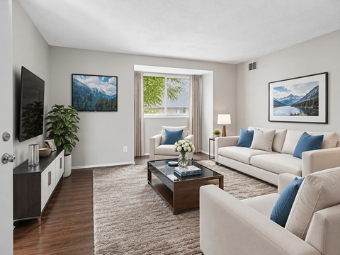 A living room with a white couch, a coffee table, and a painting on the wall.