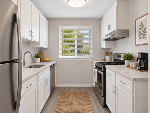 A kitchen with white cabinets and a black refrigerator.