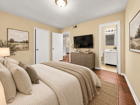 A bedroom with a large bed and a television in the corner.