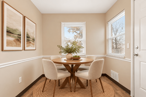 A dining room with a table and chairs.