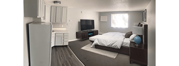A bedroom with a bed, dresser, and television.