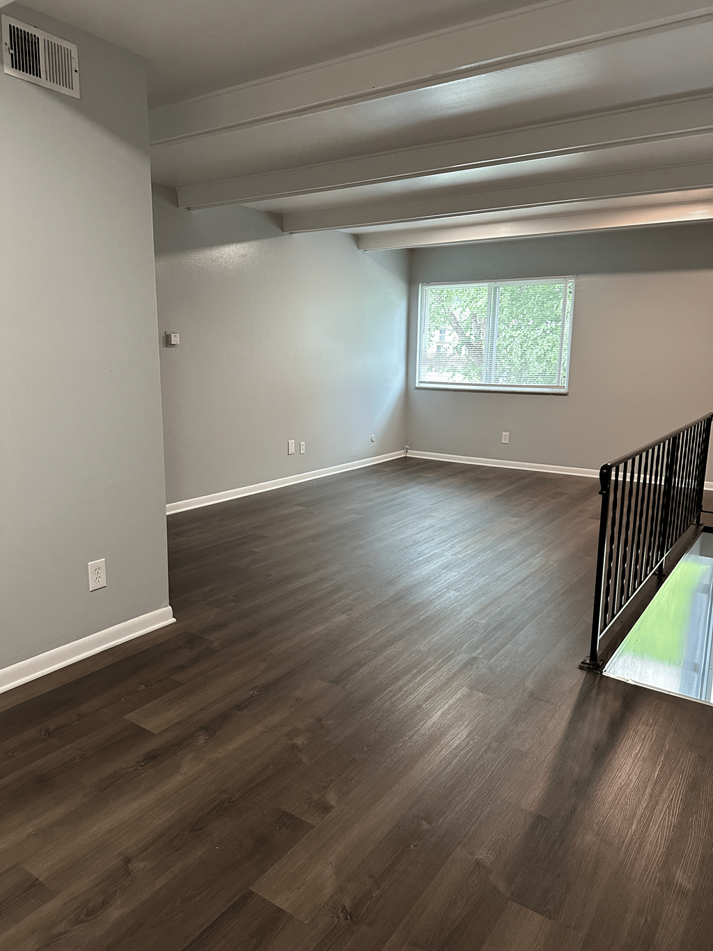 A room with wooden flooring and a window.
