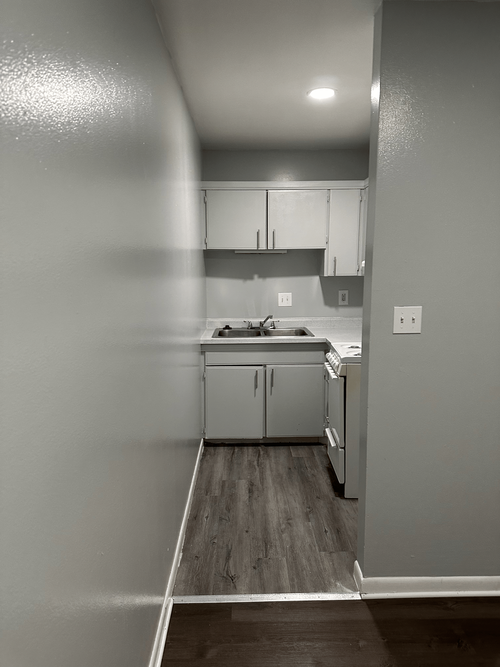 A kitchen with white appliances and cabinets.