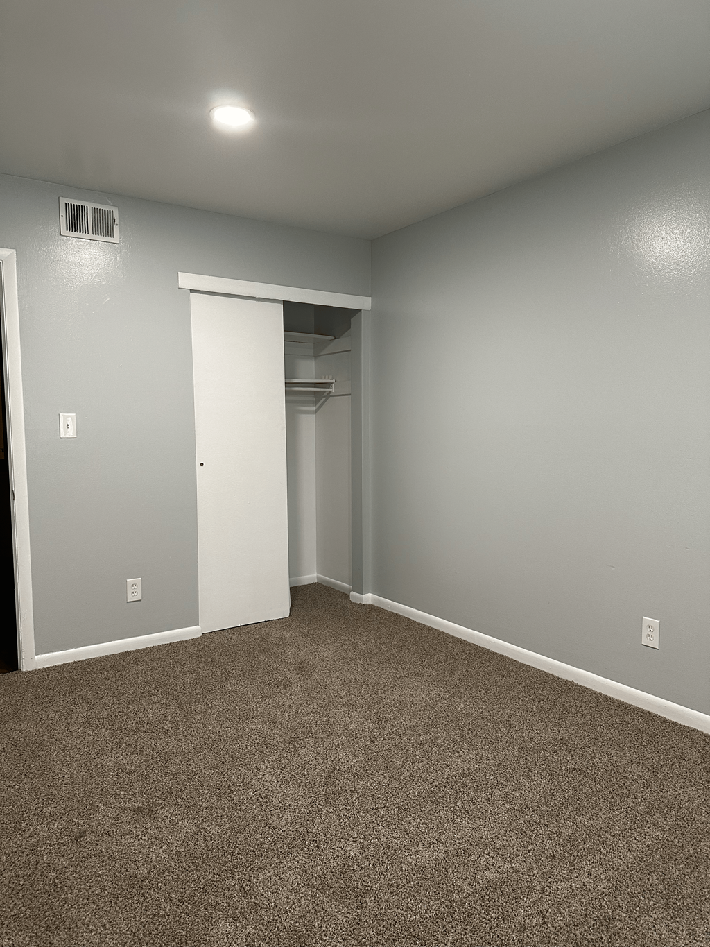A room with a carpeted floor and a white door.