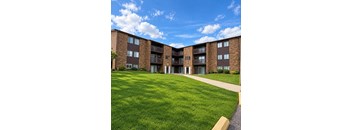 Apartment complex with a green lawn in front.