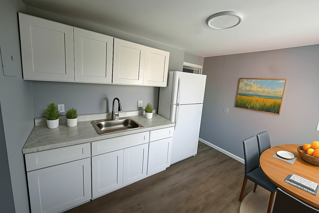 A kitchen with white cabinets and a white fridge.