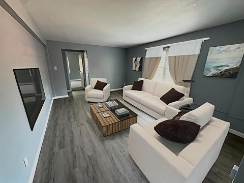 A modern living room with a white sofa and a wooden coffee table.