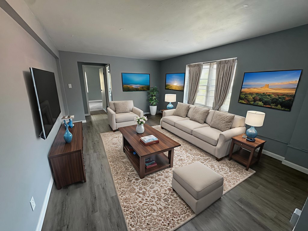 A living room with a couch, chair, and television.