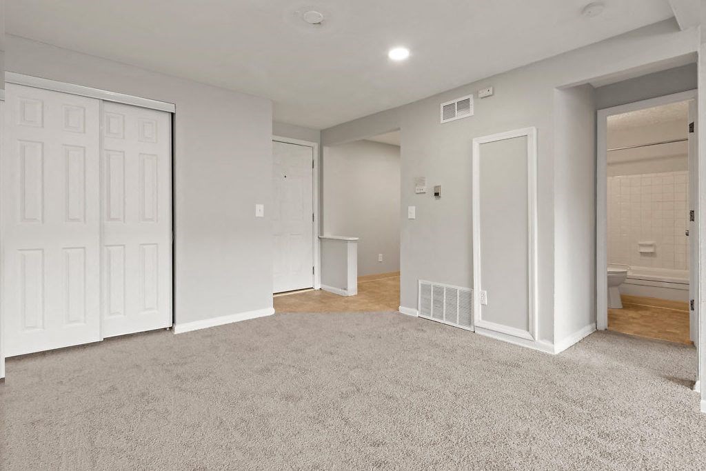 a bedroom with two closets and a door to a bathroom
