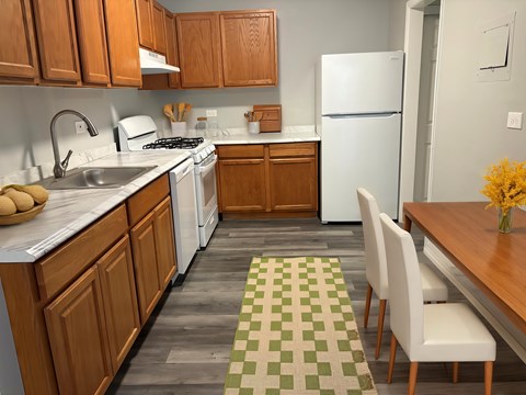 A kitchen with wooden cabinets and a white fridge. at The Langston Views, Washington