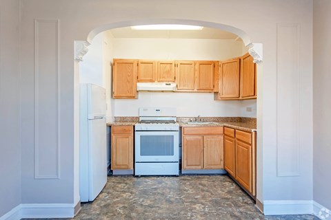 A kitchen with wooden cabinets and a white refrigerator.