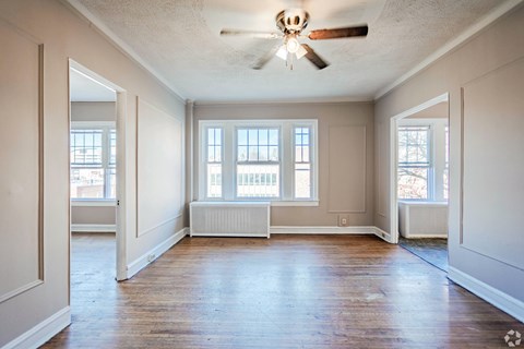 A room with a ceiling fan and a window with blinds.