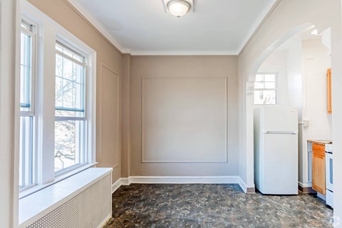 A room with a window, a white refrigerator, and a counter.