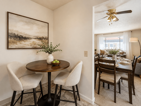 A dining room with a table and chairs.