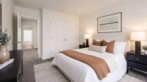 A bedroom with a large bed and a painting on the wall.