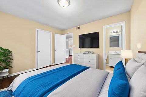 A bedroom with a bed, dresser, and mirror.