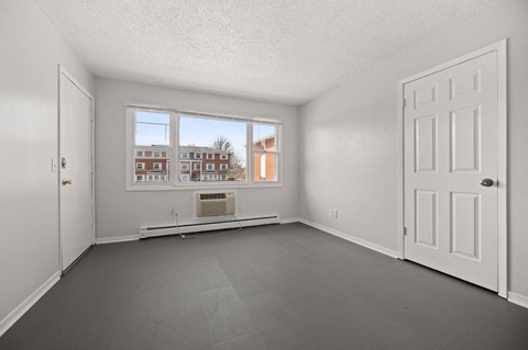 A room with a large window and a view of a building outside.