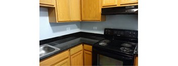 Black stove top oven with cabinets in kitchen at The Terraces at Dekalb, Dekalb, IL, 60115