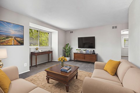 A living room with a brown coffee table and beige couches.