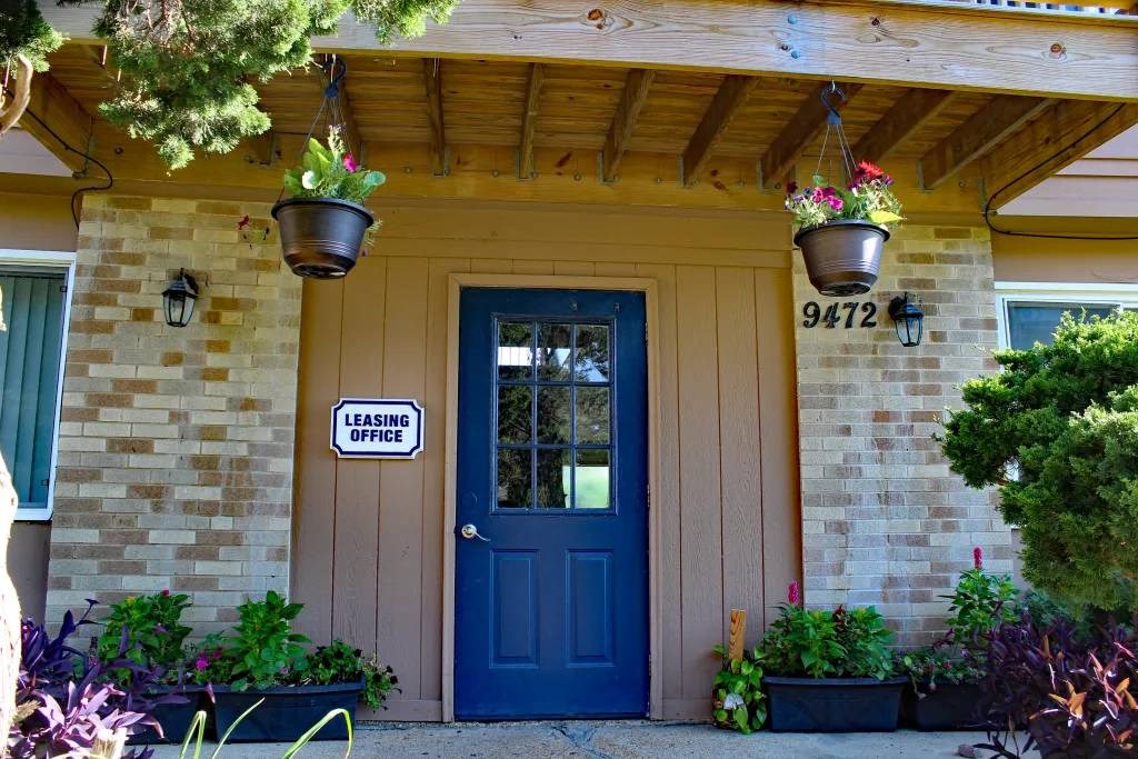 a house with a blue door and two hanging flowerpots