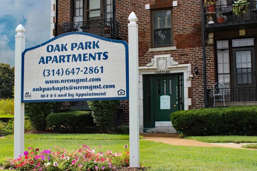 a sign in front of a building that says oak park apartments