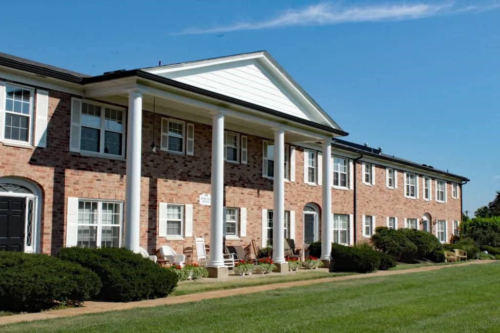 a building with columns and a grassy area in front of it