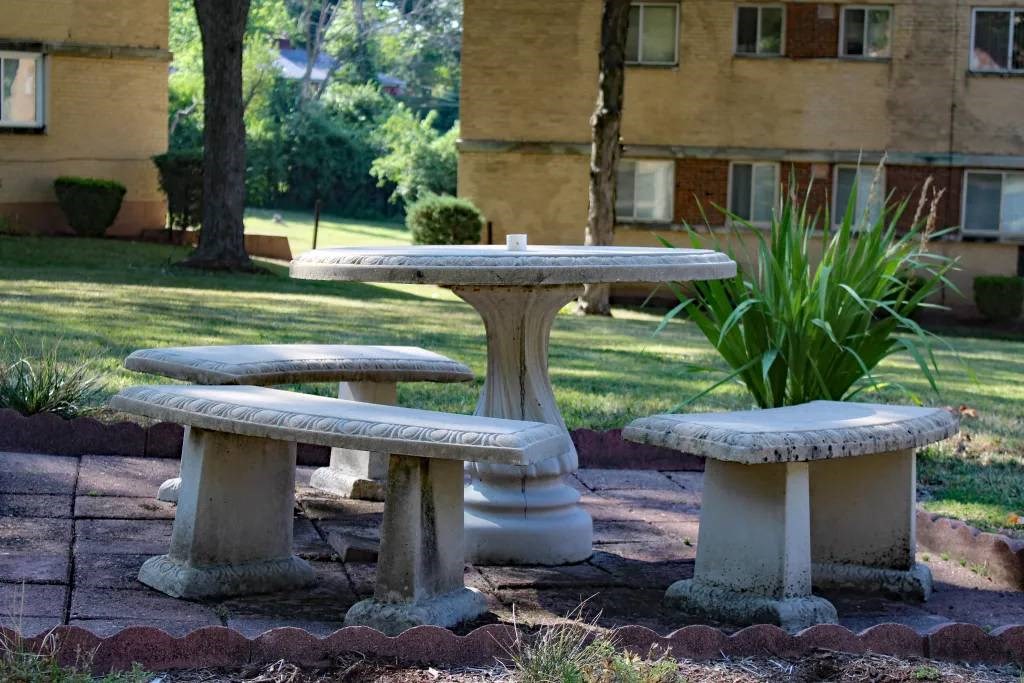 a group of benches sitting next to a lush green field